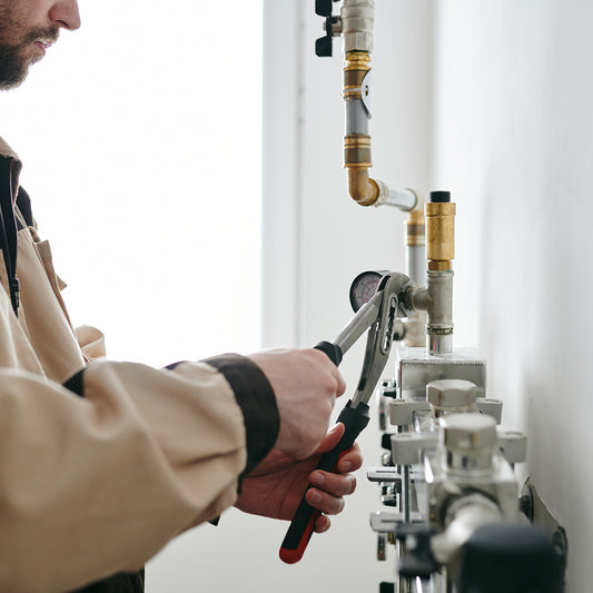 repairman with wrench fixing details of pipe